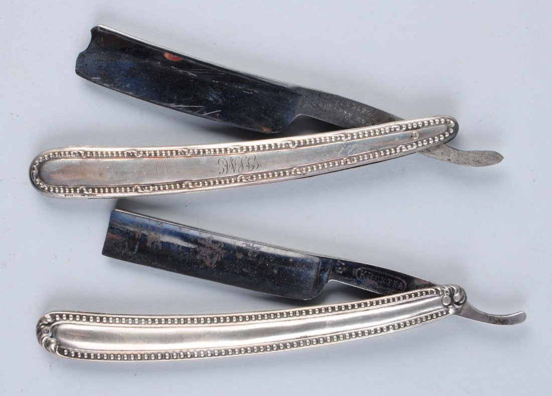 Lot of 2: Matching Sterling Razors.: Pair of sterling handled straight razors of European manufacture. Razors are of similar design in that the handles are bordered by sterling beadwork. One razor is a wedge blade while the other is conc