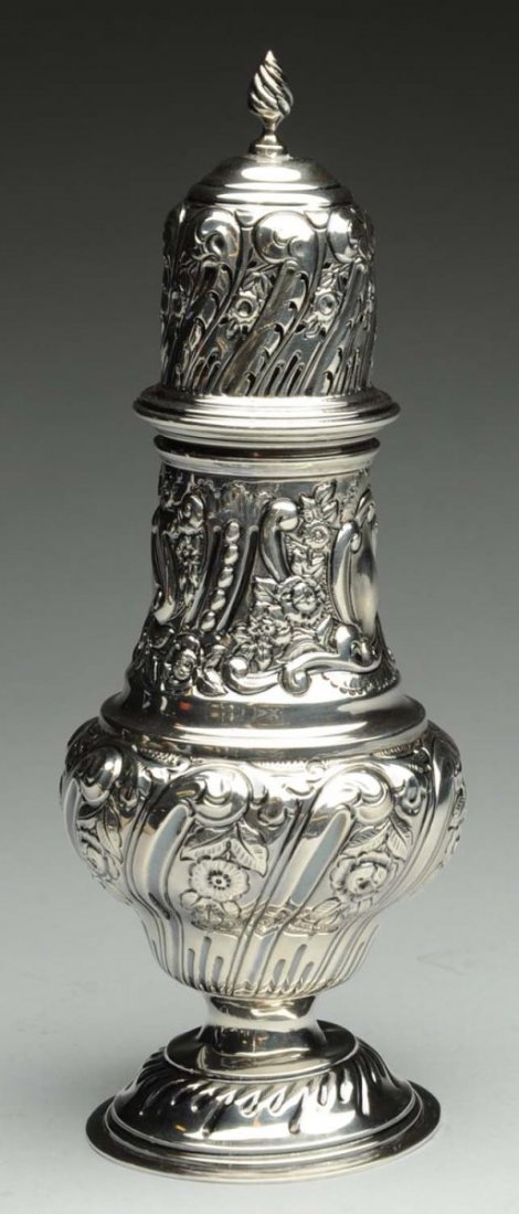 English Silver Sugar Caster/ Muffineer.: Chester 1908 Nathan & Hayes, baluster form body, pierced top with a wrythen finial, all chased with scrolls and foliage. Height: 8-1/2 in Notes: - twists to foot at junction with body - signs of use a