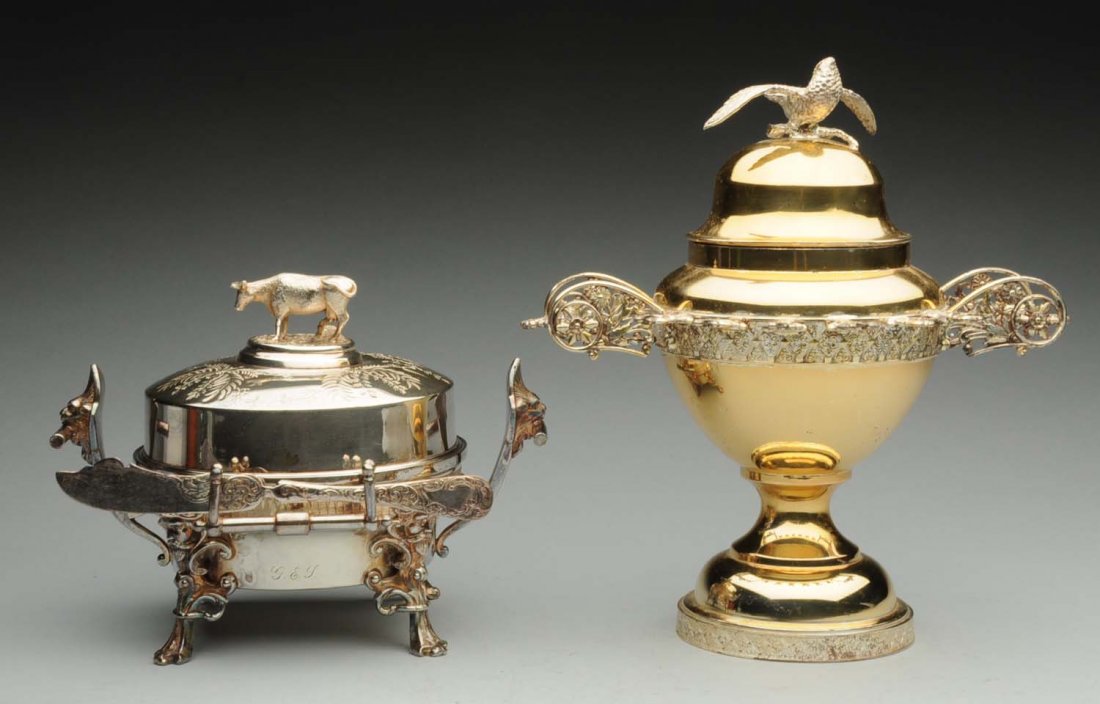 Silver Plate Butter Dish.: Meriden, circular with a finial cast as a figure of a cow, with strap handles and lion's mask bosses (replated); together with plated a part-gilt sugar bowl, Simpson Hall & Miller. Height of butter di
