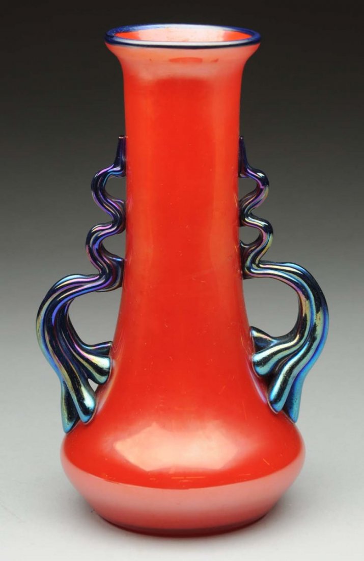 Loetz Red Vase with Cobalt Handles.: Rare Loetz vase in iridescent red with applied cobalt squiggle handles, circa 1918. Signed on base with the oval Czechoslovakia acid mark. Condition (Excellent). Size 7 - 1/2" T.
