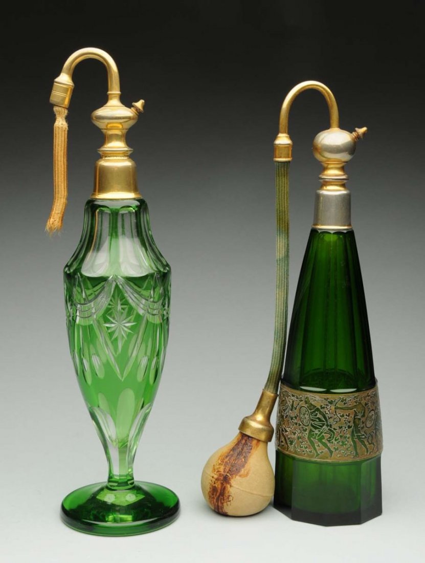 Lot of 2: Art Glass Perfume Bottles: With atomizers. Both in green glass; one is cut, the other has etched glass. Bottle with etched glassis marked Cristaline Karlovy Vary Boheme. The rubber attachments are either missing or hardened. Co