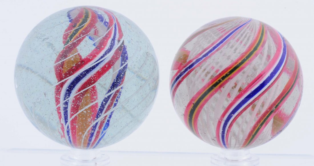 Lot of 2: Large Swirl Marbles.: The smaller one is a white latticino core and the larger one is a multicolor divided core. Both have faceted pontils and circular subsurface reflection. Condition (8.8). Size 2" to 2 - 5/32" Dia.