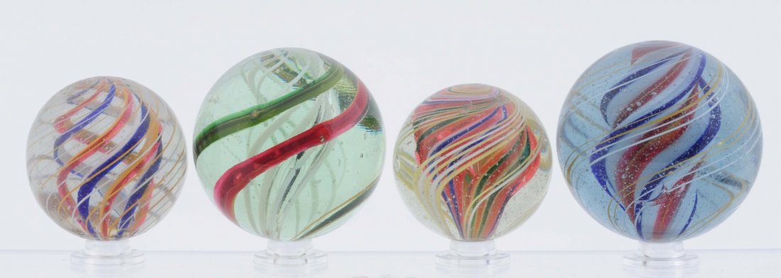 Lot of 4 : Large Swirl Marbles.: Lot includes: two multicolor divided core swirls, one white latticino core swirl, and one white, red, yellow and blue ridge core swirl. All four marbles are polished with small damages still remaining