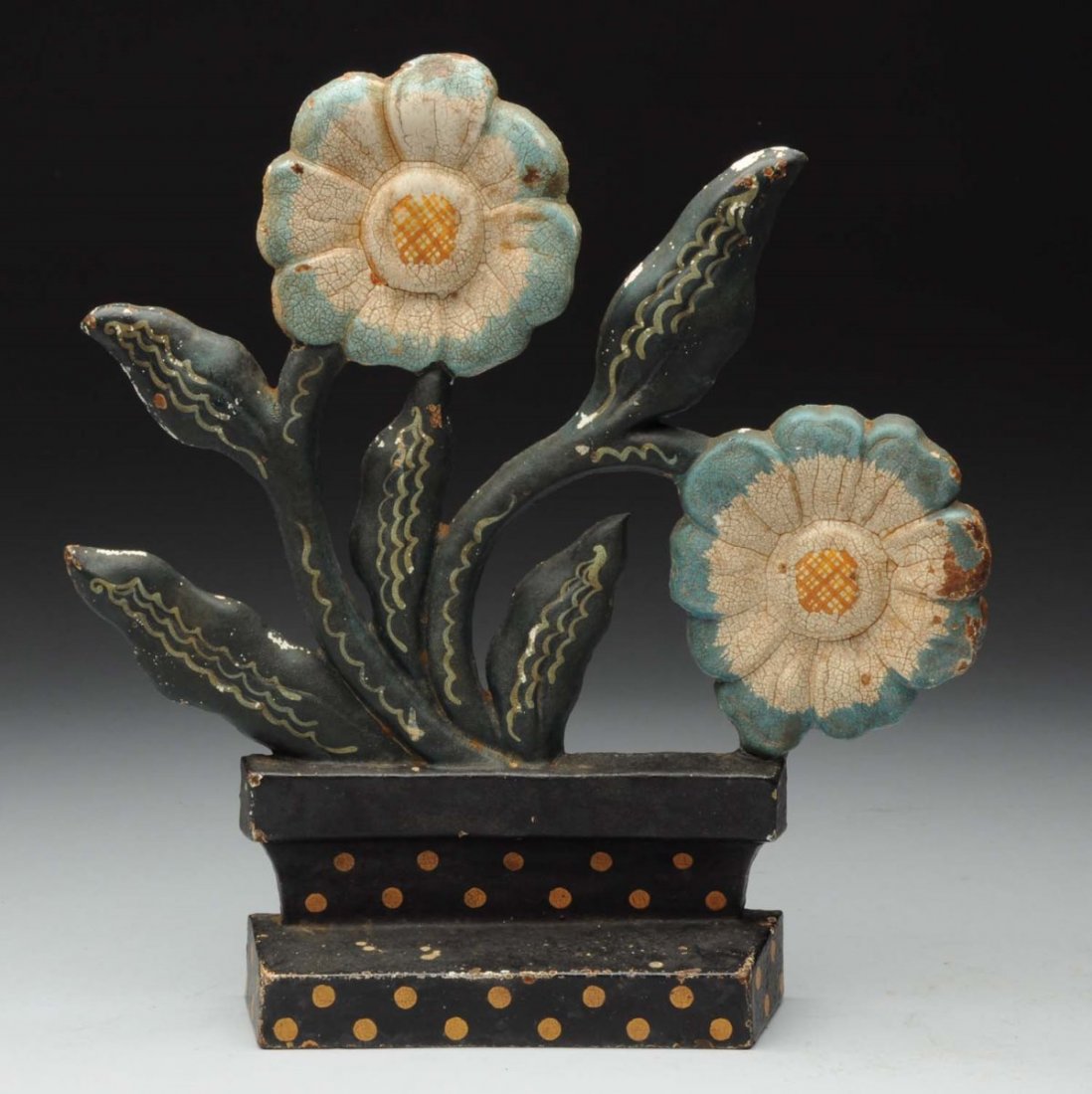 Cast Iron Modernistic Flower in Pot Doorstop.: Oversize flower blooms in polk-a-dot pot. Crack in casting where flower connects to pot. Condition (Very Good). Size 10" T.