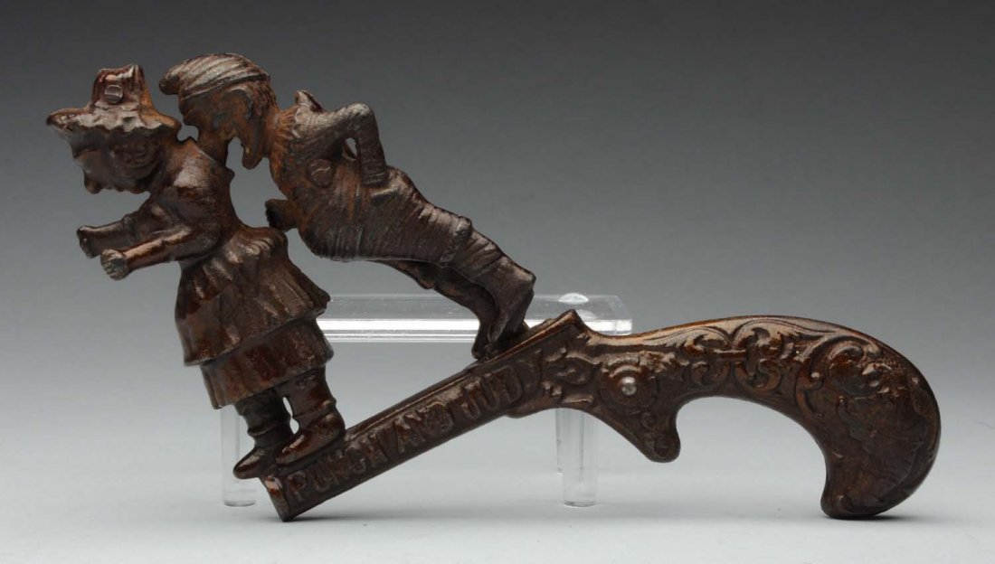 Early Ives Cast Irong Punch & Judy Cap Pistol.: Late 19th Century. Embossed "Punch & Judy" on one side of pistol. Working. When trigger is pulled Punch's nose goes into Judy's back. Some Japanning loss and some pitting. Condition (Very Good - Excel