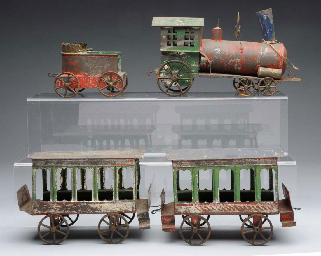 Early American Tin Passenger Train Set.: Late 19th century. Includes: Steam type engine with cow catcher that is missing the bell, matching four wheel tender with scalloping on back, and two matching passenger cars. Beautiful as found all or