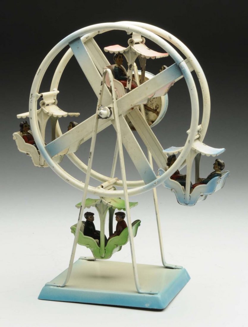 German Tin Litho Ferris Wheel Toy.: Two lithograph figures in each of the four carts. When wound ferris wheel spins around. Some paint loss and wear especially to supporting bar. Oxidation to top of carts. Condition (Very Good). Size 9