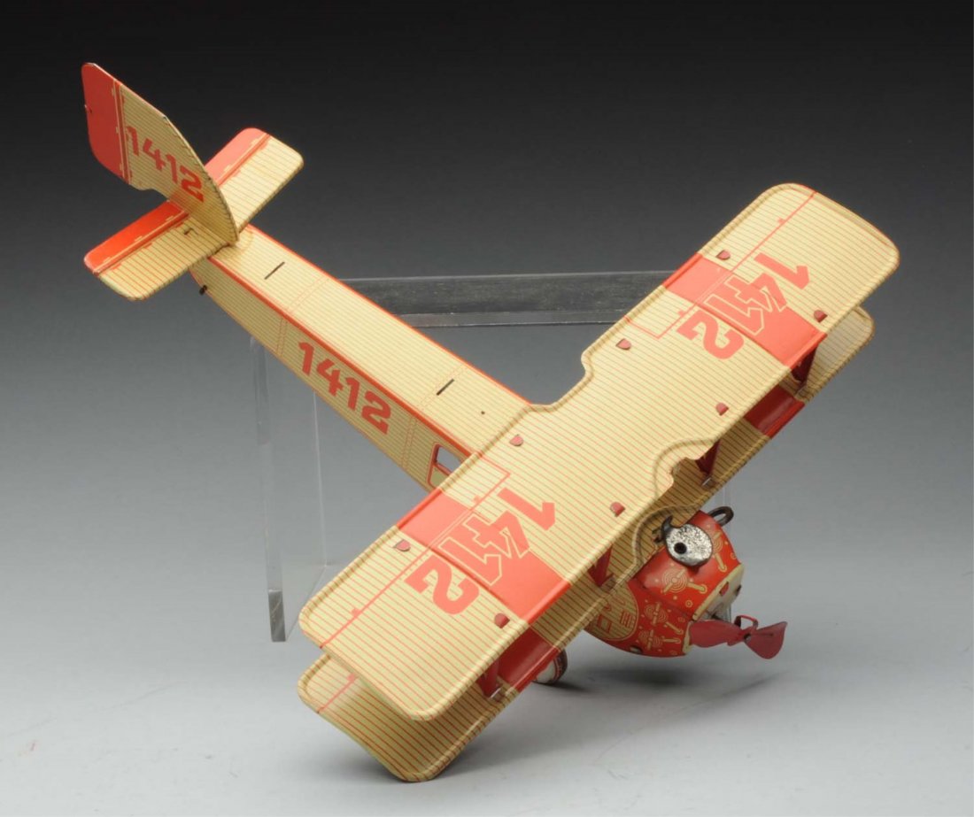 German Tin Litho Wind - Up Bi-Plane.: All original including front propeller. Very nice lithography. Marked "1412" on wing fuselage and back tail in. Wheels marked "Balloon Tyre". Very little wear. Condition (Near Mint). Size 11 - 1/2" L.