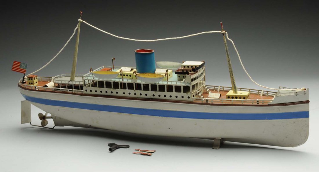 German Fleischmann GFN Clockwork Ocean Liner.: Original tin litho American flag on the rear, and two original but detached flags for each mast. Includes three of the original four lifeboats. The blue striping on the sides of the hull look to be re