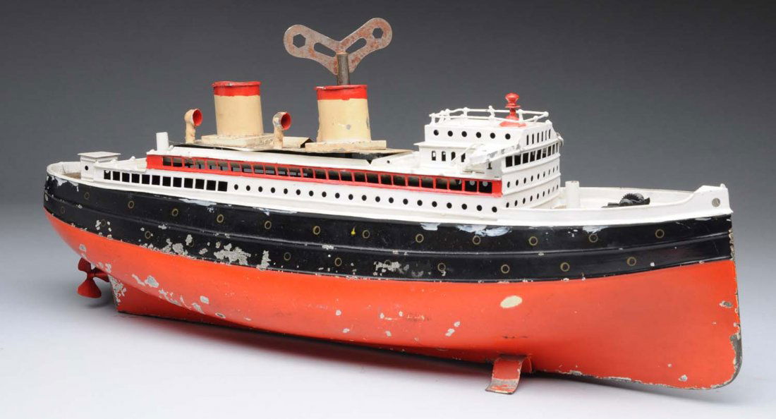 German Hand Painted Fleischmann's Ocean Liner.: Clockwork. Has "G.F.N." mark on front of deck. Missing one funnel and two masts, and also missing flags. Some denting and paint loss to hull. Paint flaking and wear to deck. Condition (Good - Very Goo
