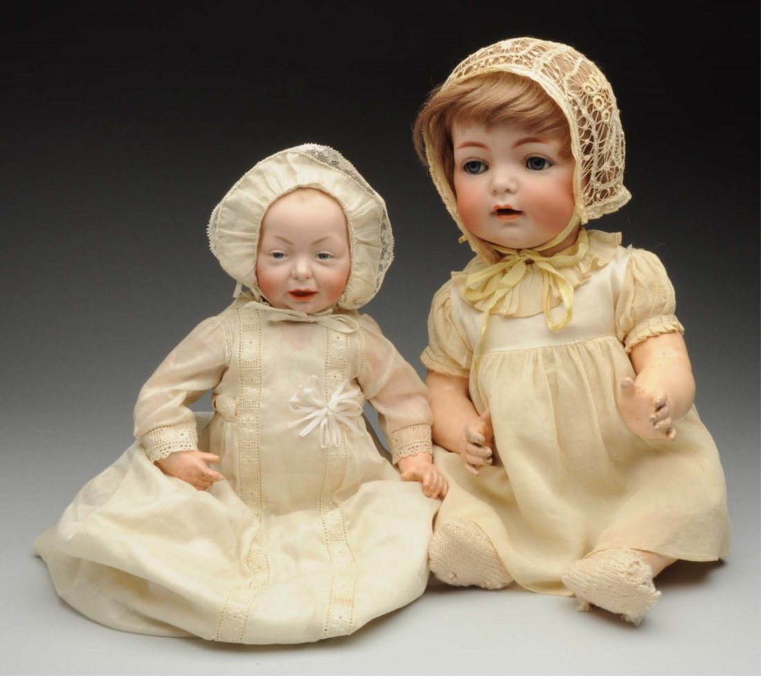 Lot of 2: Baby Dolls.: German bisque socket head incised “K [star] R Simon ^ Halbig 121” with smiling face, sleeping eyes, open mouth with two upper teeth, dimples, replaced human hair wig; original composition baby bod