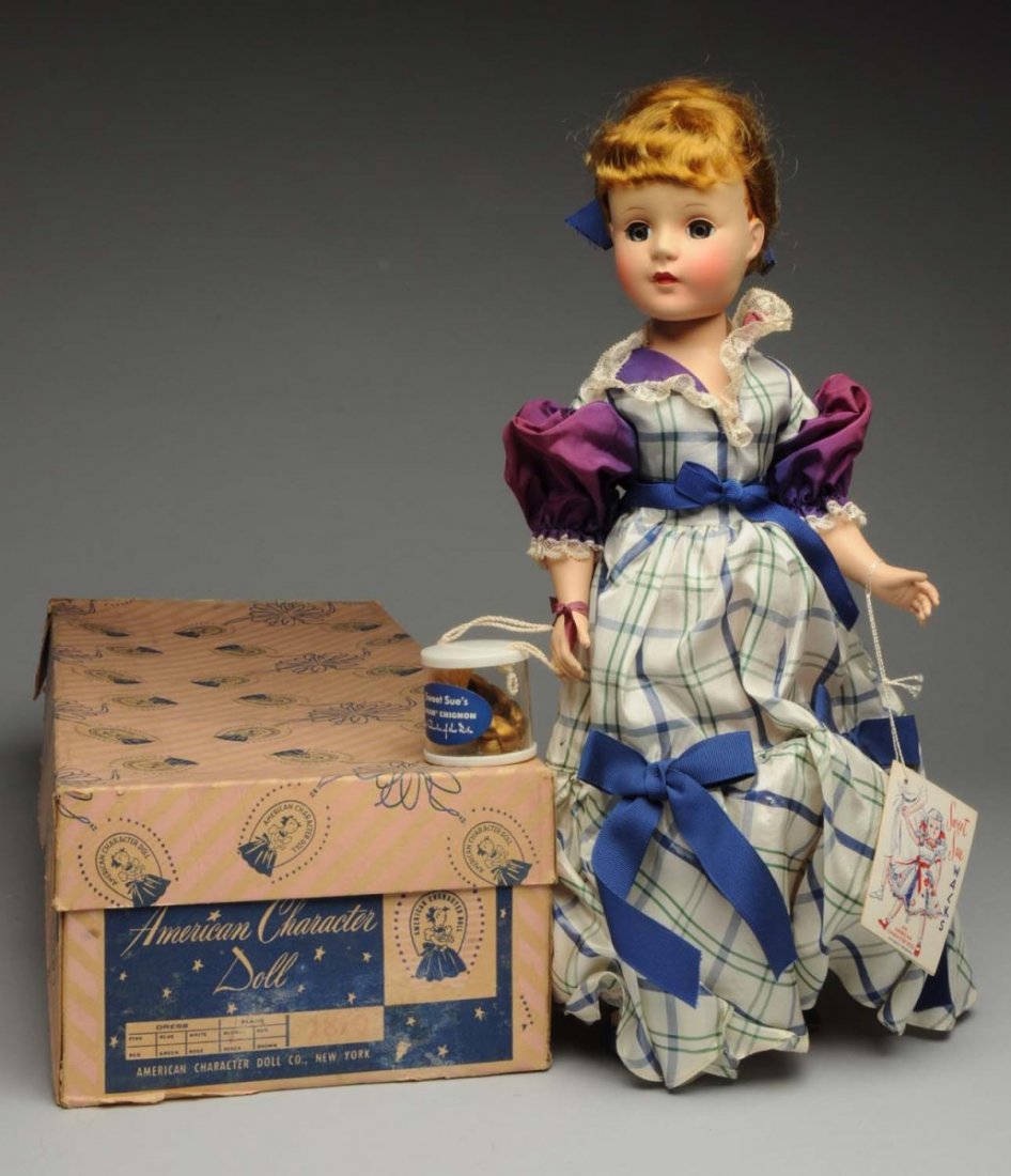 American Character “Sweet Sue” Doll.: All hard plastic walking doll with lovely fancy hairdo (glue residue) with extra boxed hairpiece, all factory original gown (light fading on sleeves), undies and shoes; with wrist tag and sheet of dir