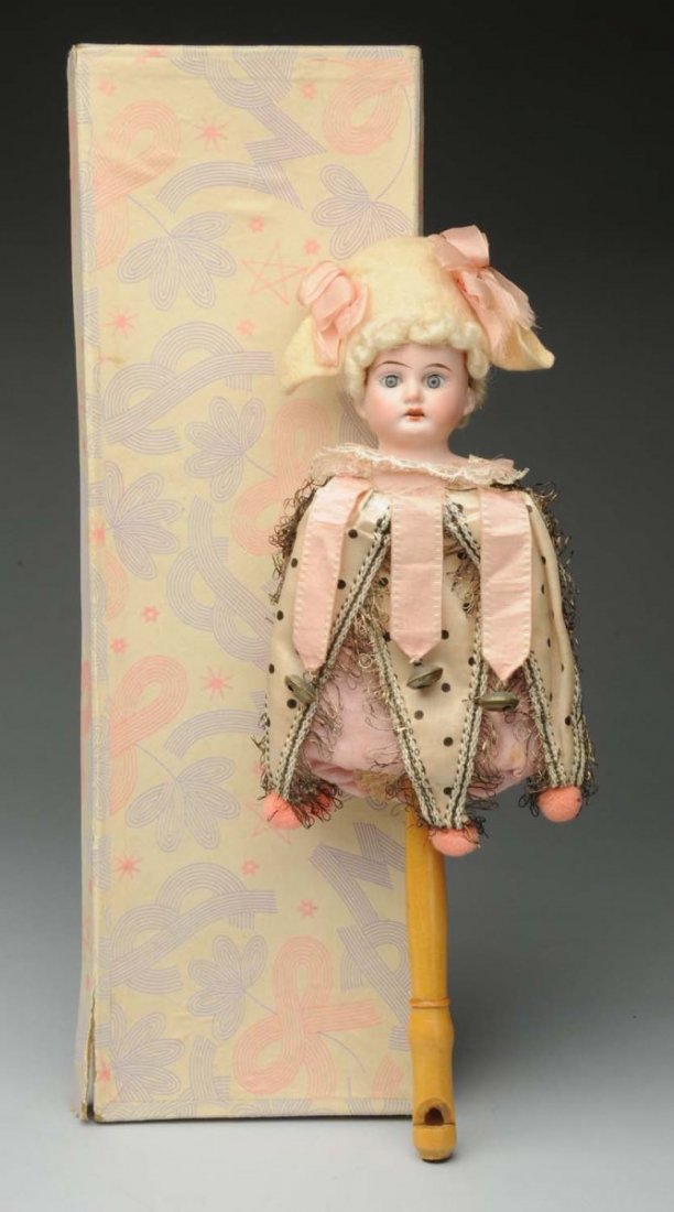 Fabulous Marrotte Toy.: A.M. bisque shoulder head on a stick with a bellows inside that squeaks when shaken; wood handle forms a whistle; totally original including wig and hat, bells, pompoms and metallic trim. In original