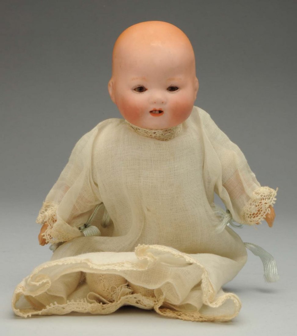 Tiny German Bisque Baby.: Flange head incised “A.M.” with painted hair, sleeping eyes, open mouth, original cloth body with composition hands, original factory gown, slip and undies. Crisp and perfect! Condition (Excellent