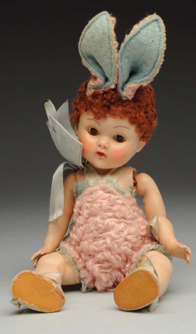 Vogue Hard Plastic “Easter” Doll.: “Fluffy” Crib Crowd baby, special for1951-52 with caracul wig, sleeping eyes, rosy cheeks, all original outfit with bunny ears and tail (stringing loose, some discoloration to legs). Very rare to 