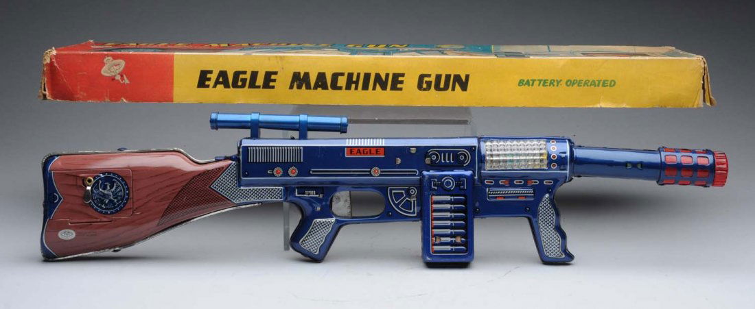 Japanese Tin Eagle Machine Space Gun.: Battery - operated. Gun itself is made of tin litho and he barrel has a plastic part; some scratches throughout the tin litho. Also includes original box; some creasing and paper tear. Condition (Exce