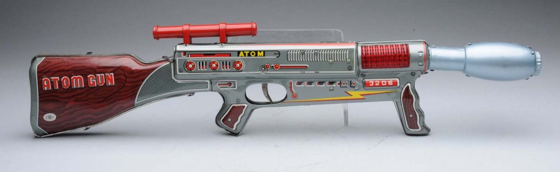 Japanese Tin Friction Powered Atom Space Gun.: Very small light scratched on the tin litho. In working condition. Comes with original box; some slight creasing and paper pull. Condition (Excellent - Near Mint). Size 24" x 5 - 3/4"