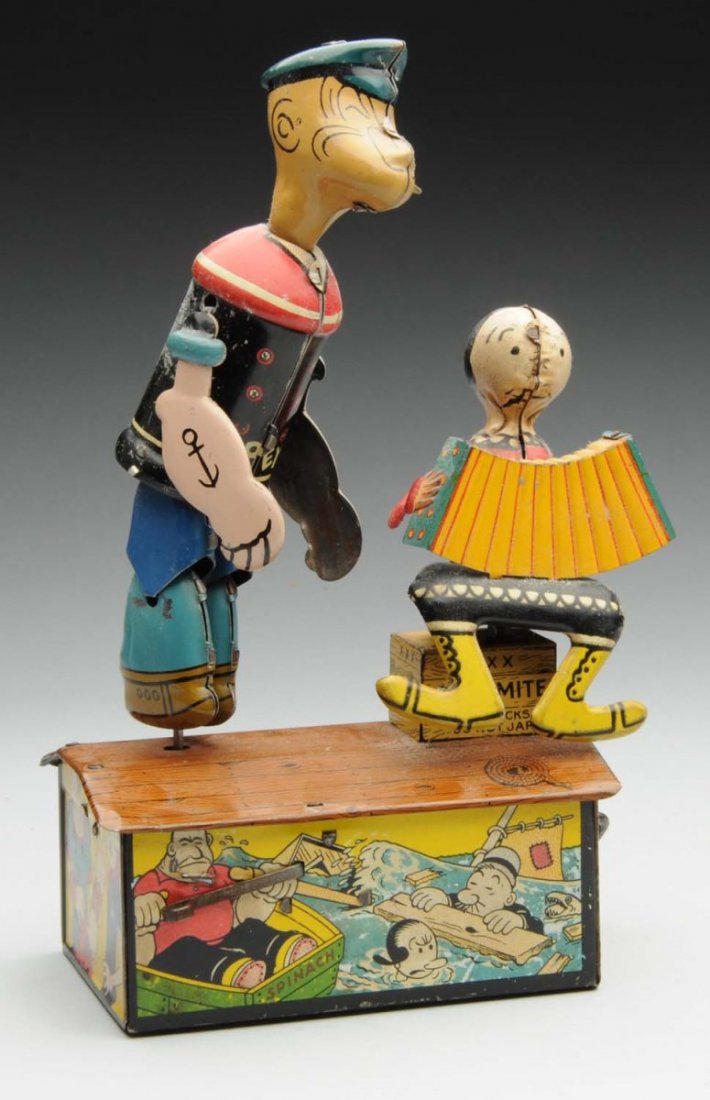 Marx Tin Litho Popeye and Olive Oyl Roof Jiggers.: Wind-up. Depicts Popeye dancing on roof while Olive Oyl plays an accordion. Olive Oyl is missing her wire hair bun, and has a mold flaw on the left side of her face. Popeye has original arms and pipe.