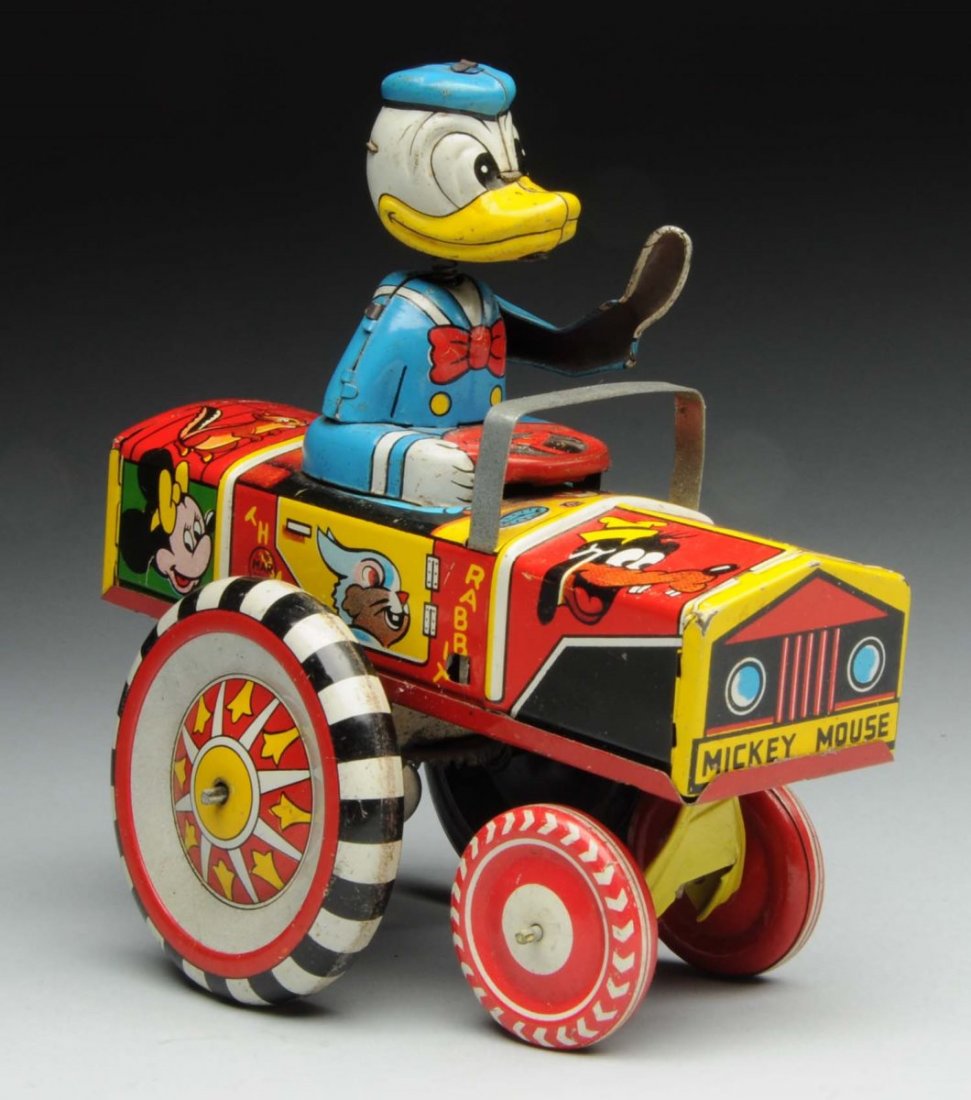 Marx Wind-Up Walt Disney Donald Duck Dipsy Car.: Tin litho toy is marked "Walt Disney Productions" on the rear. This version has a metal head on a spring, and a metal arm. Nice depiction of colorful Disney characters around the sides of the car. Som