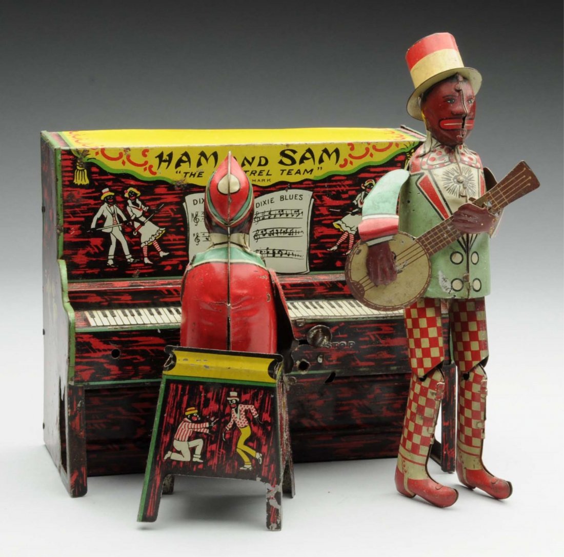Strauss Tin Litho Wind-Up Ham & Sam Minstrel Band: Depicts African Americans playing the banjo and piano. Includes original hat and arms and banjo. Some scratching and wear. Condition (Very Good - Excellent). Size 7" L.