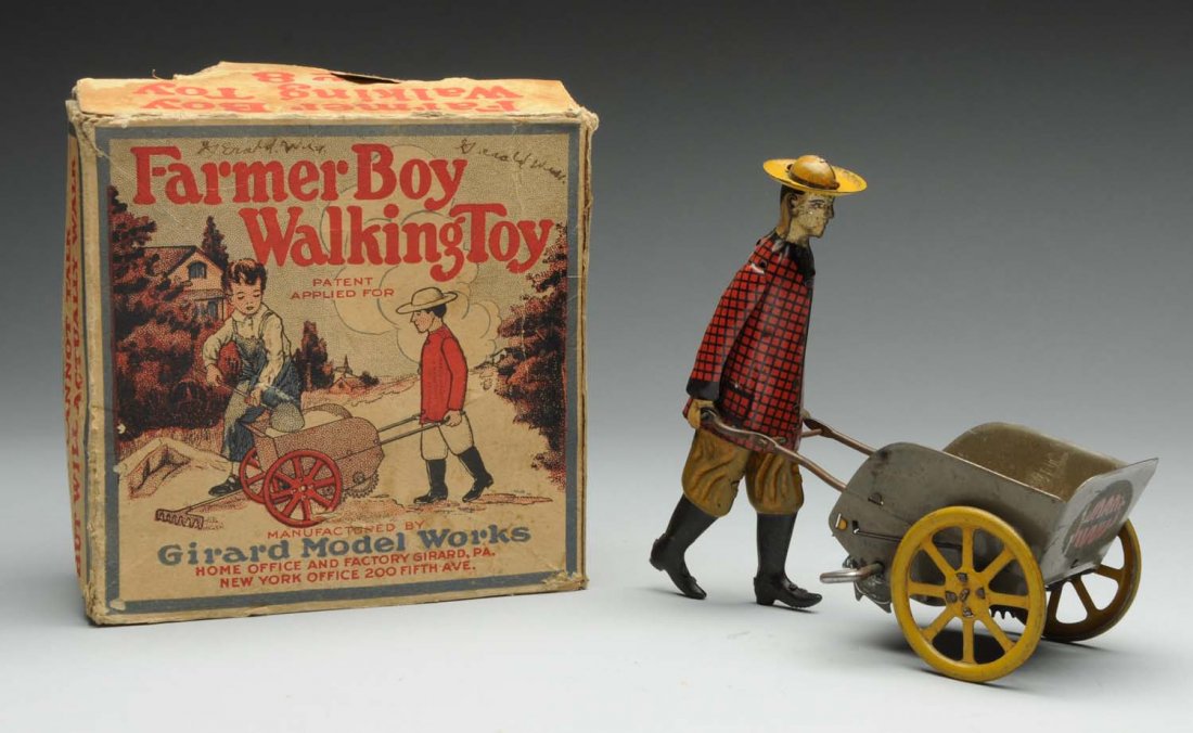 Girard Tin Litho Wind-Up Farmer Boy Walking Toy.: Nice original box with beautiful graphics on sides. Toy itself depicts farmer walking with wheelbarrow type cart. Some general wear throughout. Very early toy. Condition (Very Good). Size 6" L.