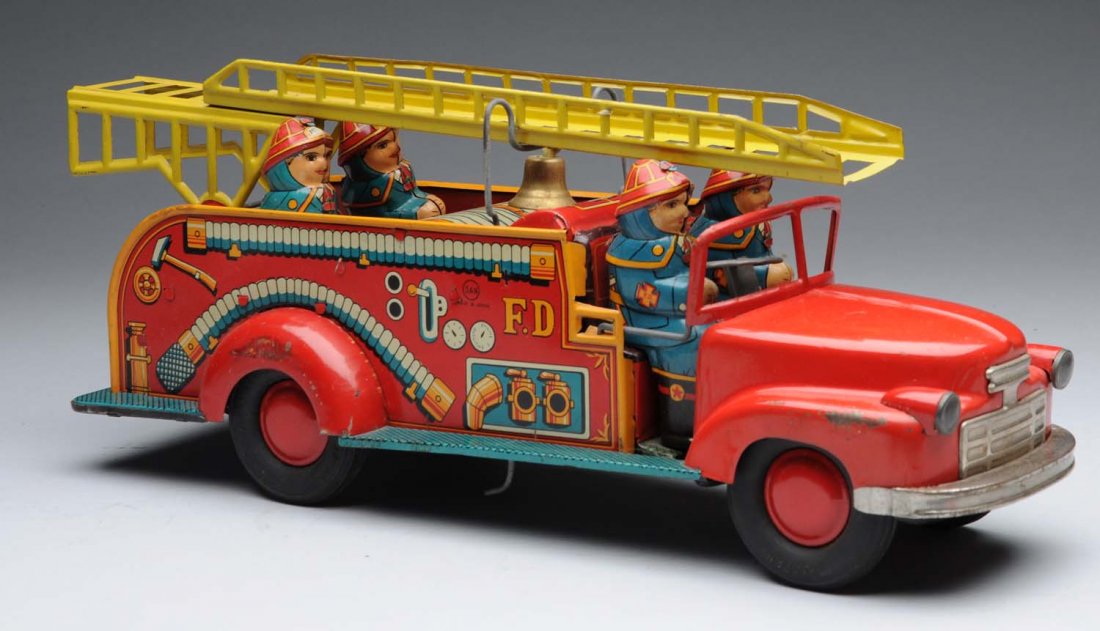 Tin Friction Large Ladder Fire Truck in Box.: Circa 1952, Marusan, Japan; large, detailed tin friction with 4-dimensional firemen; minor areas of paint loss to fenders above wheels; box is rough with stains and a faded label; missing one end pane