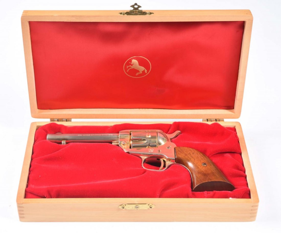 1961 Colt .22 Kansas Centennial Comm. Revolver.**: Serial No. 5302G. This is a Colt Scout Kansas Centennial commemorative single action .22 revolver. Gun is new in original Colt display case. Gun has 4-1/2” barrel and is entirely gold plated. Wood g