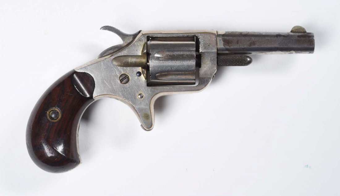 Colt Etched Panel New Line .22 Revolver.: Serial No. 51179. Manufactured 1877. Standard with 2 ¼” octagon barrel, spur trigger, nickel finish, birds head grips, single action in .22 caliber with 7 round fluted cylinder. Perfect etched pane