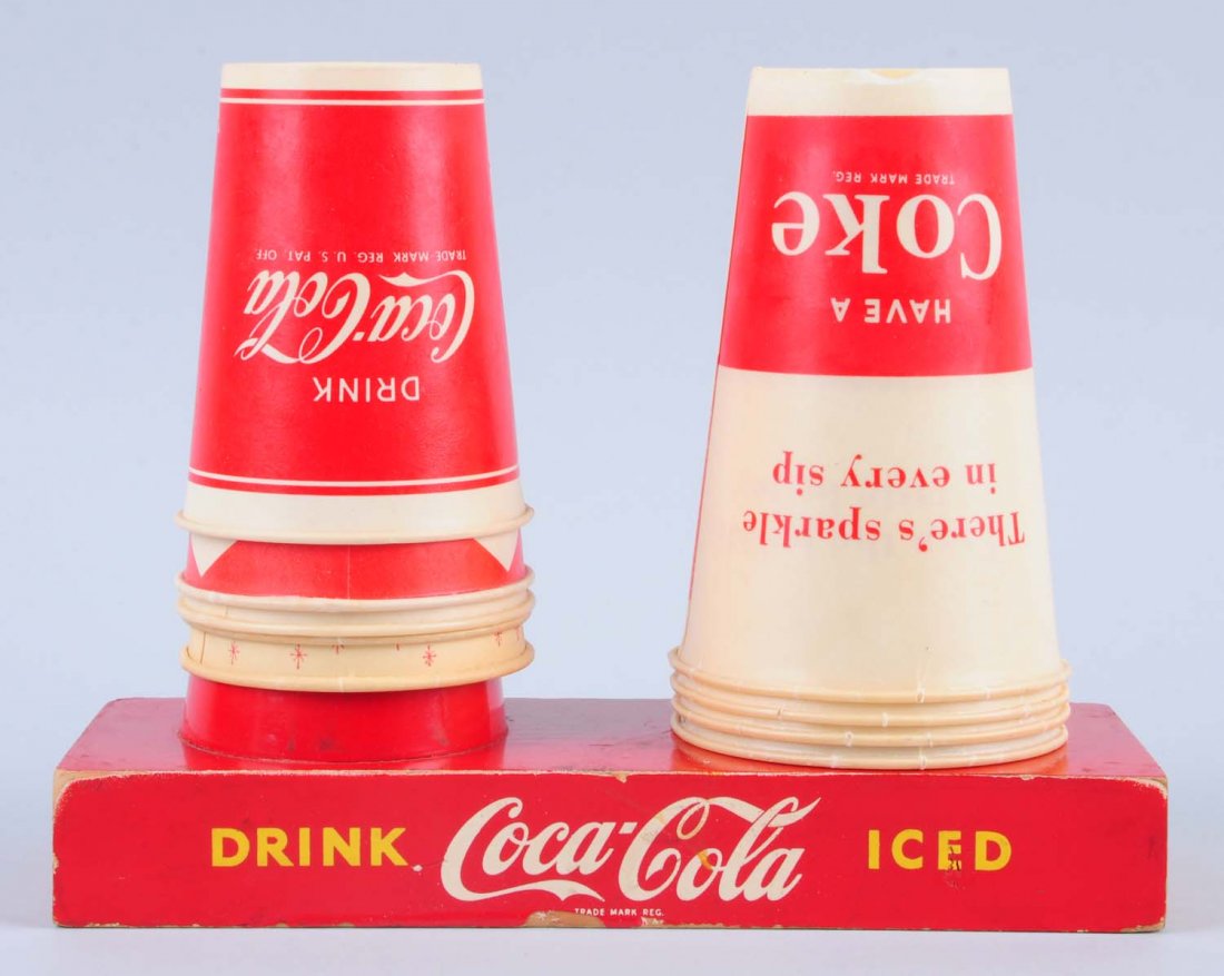 194s Coca - Cola Cup Holder.: This countertop cup holder holds two stacks of cups. A few small chips. Several vintage cups are included. Condition (Very Good Plus). Size 9" L.