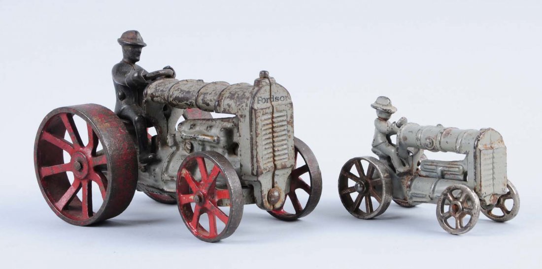 Lot of 2: Cast Iron Arcade Tractor Toys.: Lot includes: Small version has a molded driver, and larger one has removable driver. Both have some paint loss and wear. Condition (Very Good). Size Largest : 5 -1/2" L.
