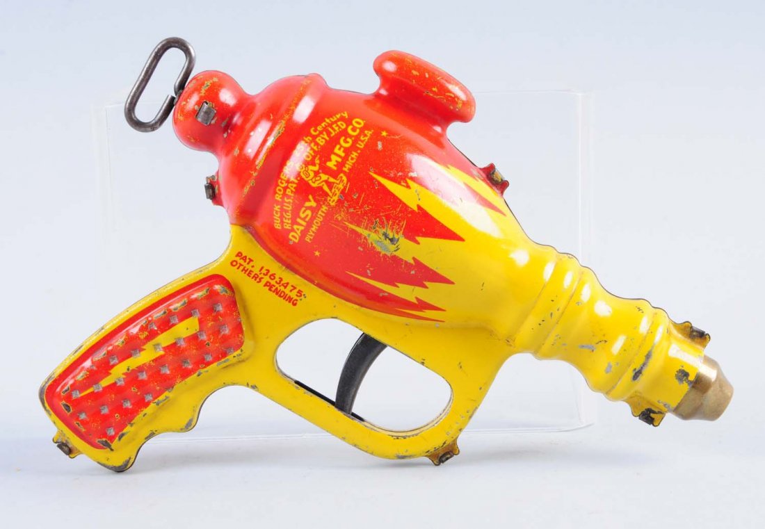 Pressed Steel Buck Rogers Water Pistol.: Made by Daisy Manufacturing Co. Some significant spots of paint chips, loss and scratches throughout the pistol. Pistol is still very attractive and bright. Includes back mechanism to pump the water.