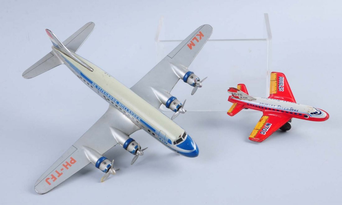 Lot of 2: Tin Airplanes.: One plane is a friction tin litho airplane, has scratches and oxidation. The other plane is a plane with four propellers, wind - up but the key is missing. The back wheel is missing as well. Condition