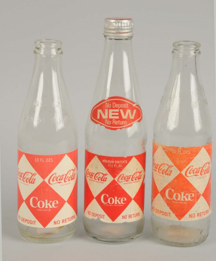 Lot of 3: 1960s Bottle Diamond Coca-Cola Paper Label.: Small diamond paper Coca-Cola label bottles. Two 10 oz. and one 11 ½ oz . Screw cap. Light to moderate label soiling or wear. Condition (Very Good - Excellent). Size Largest: 8 - 3/4" T.