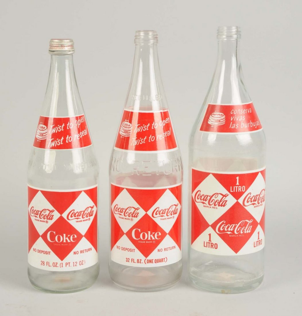 Lot of 3: Different Coca-Cola ACL Bottles.: A foreign liter, 28 oz. and 32 oz. Light wear on the group. Condition (Near Mint). Size Largest: 12" T.