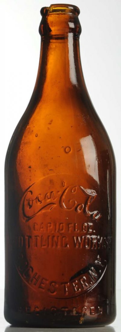 Rochester, NY 10oz. Amber Coca-Cola Bottle.: Lip chip, large closed base crack and small nicks. Condition (Good - Very Good). Size 8" T.