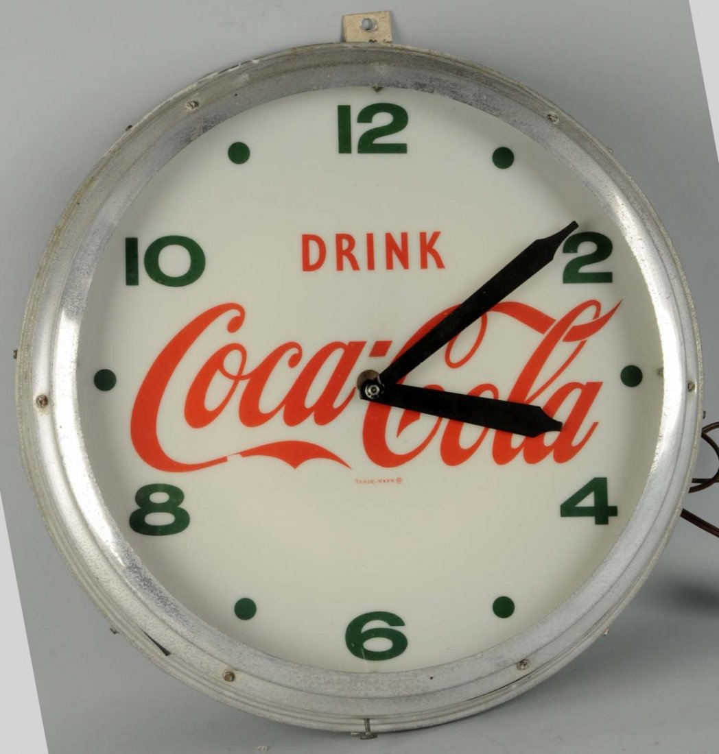 1950s Coca-Cola Outdoor Clock.: Case is weathered with mild pitting and the clock face has light wear on the logo in a few small spots. Some fasteners on clock hands non-original. Condition (Very Good). Size 22 - 1/2" Dia.