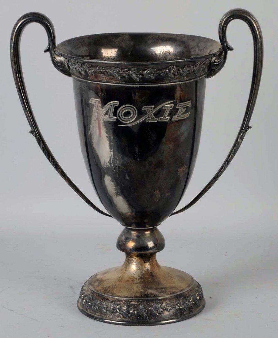Large Silver Moxie Loving Cup.: Engraved on both sides with "Moxie" and "Made by W.I. Cowlishaw in Boston". Tarnished, with some light plating wear and a few dents and pecks. Mostly to one side. Condition (Very Good). Size 15 - 3/4"