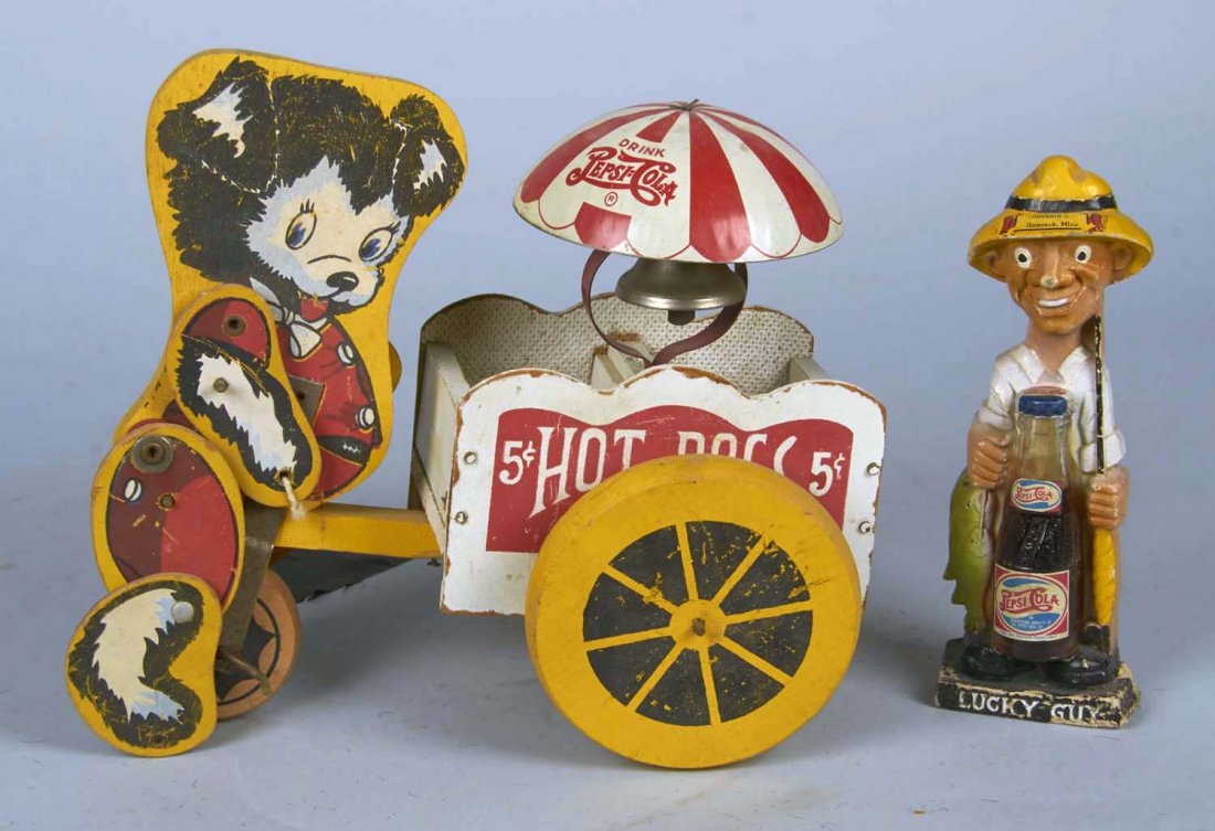 Lot Of 2 Wooden Double Dot Pepsi-Cola Figurines: Including 1 - 5 cent hot dog vendor pull toy w/dog (9" x 10.5") & 1 - "Lucky Guy" figural man w/miniature Double Dash Pepsi bottle (8" tall) Condition Very Good Size up to 9" tall