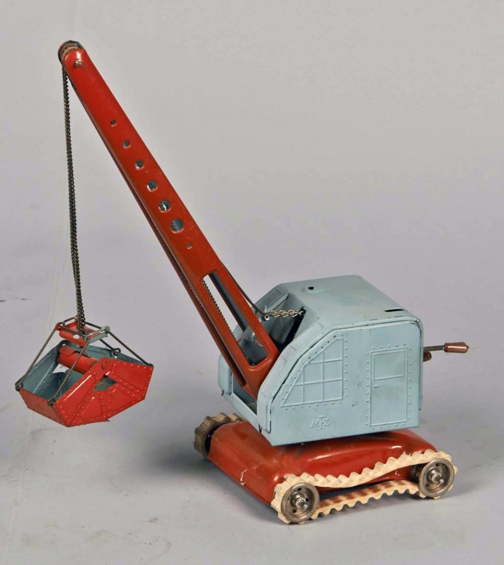 MFZ Tinplate Crane Digger Toy: Made in U.S. Zone Germany. Orange and light blue with white rubber tires. Condition (Good). Size 11" T.