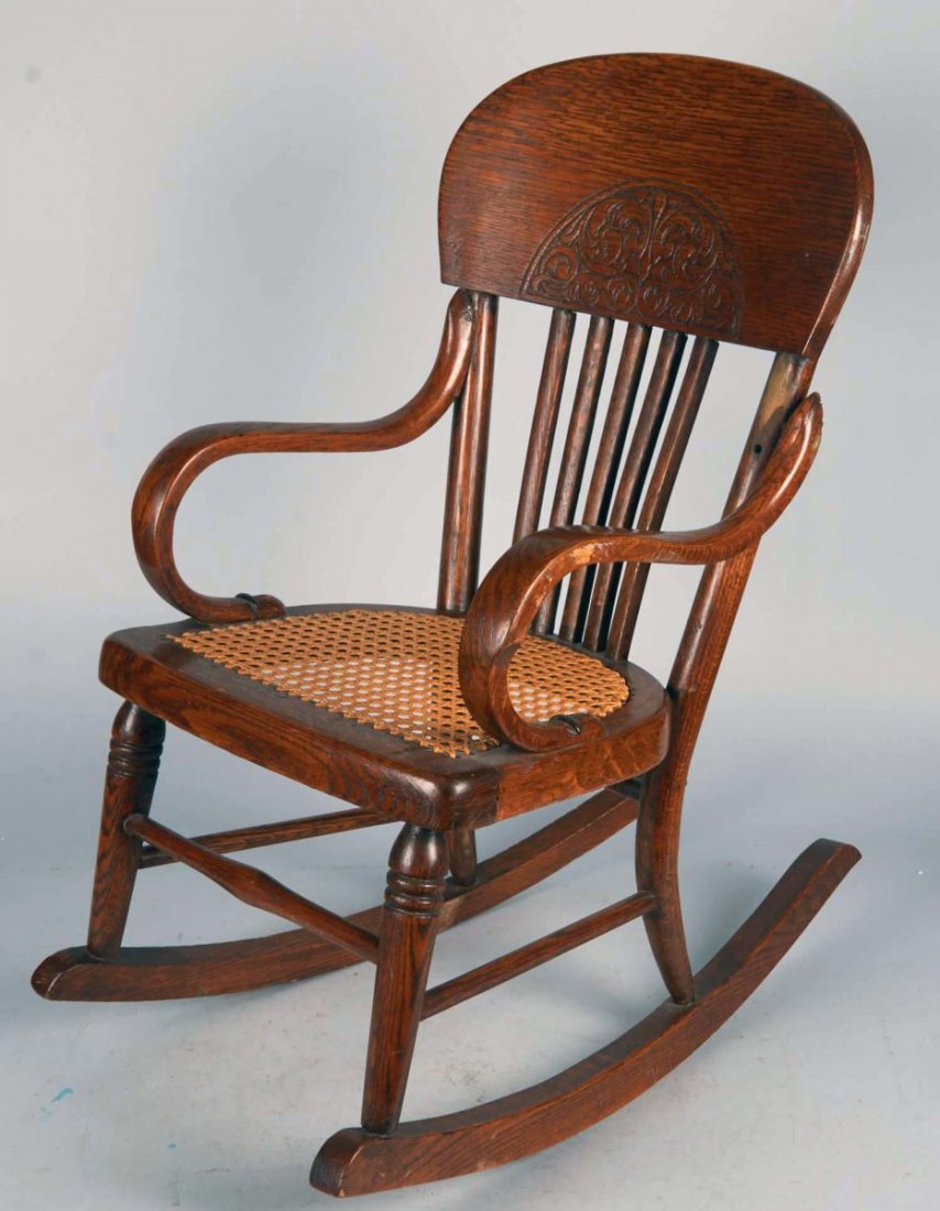 Small Wood Rocking Chair: Fancy etching on back with cane woven seat.