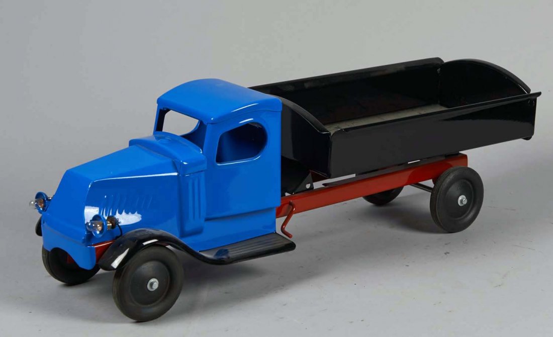 Pressed Steel Kingsbury Dump Truck: Has battery operated headlights, blue tractor, black fenders and dump, and red chassis. In very nice restored condition. Condition (Restored). Size 23" L.