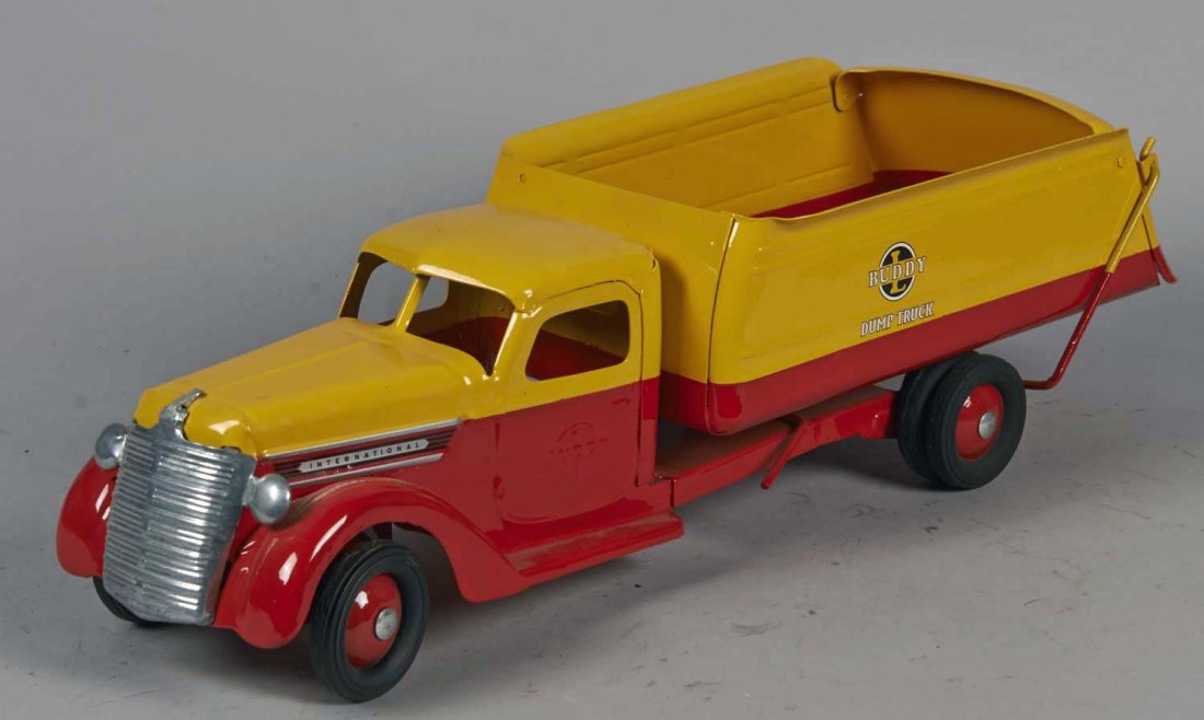 Pressed Steel Buddy L Dump Truck: Red and yellow with sloped rear and 6 rubber wheels. Condition (Restored). Size 21" L.