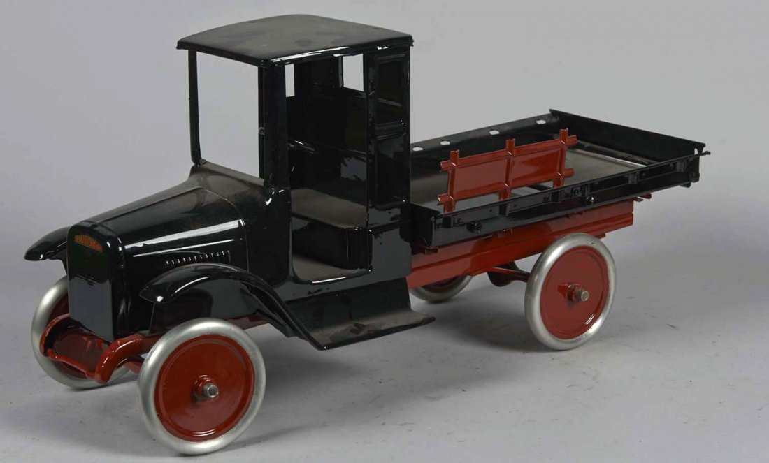 Pressed Steel Buddy L Lumber Truck: Black with maroon chassis and side stake, metal wheels, and working steering wheel. Condition (Restored).