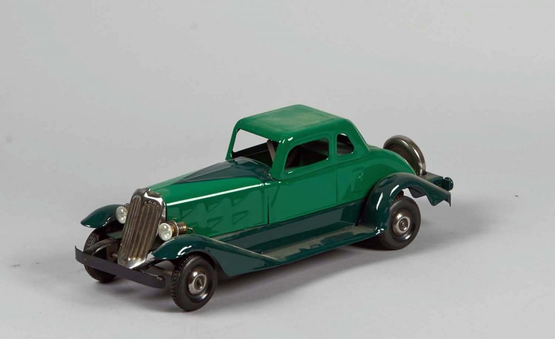 Pressed Steel Wind-Up Hoge Fire Chief Car: Restored to green and dark green with back spare tire, chrome grille and battery operated front headlights. Circa 1934. Condition (Restored). Size 14" L.