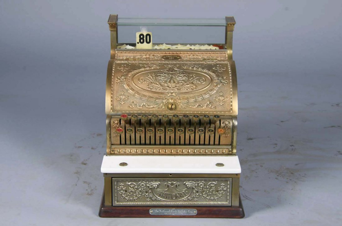 National Cash Register Brass Model 324: Serial No. 1597770 circa 1916, in Dolphin design, wood base, marble shelf, "National" nickel drawer front, plate on base. Missing dust cover with small chip in glass. Working. Condition (Very good). S