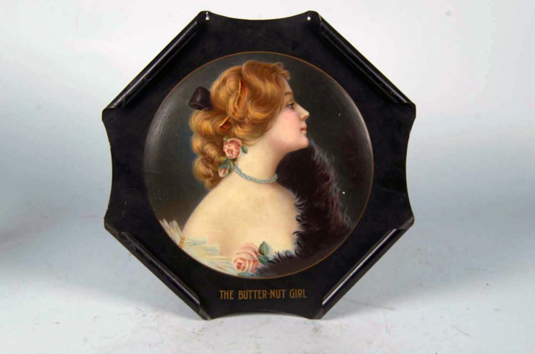 Mildred The Butter Nut Girl Tin Litho Sign: Outstanding, early, rolled-edge sign for the Butter Nut Co. featuring a great color graphic of a blonde woman named Mildred. Marked; "Copyright 1907 The Meek Company 80". Some fine crazing and a scrat