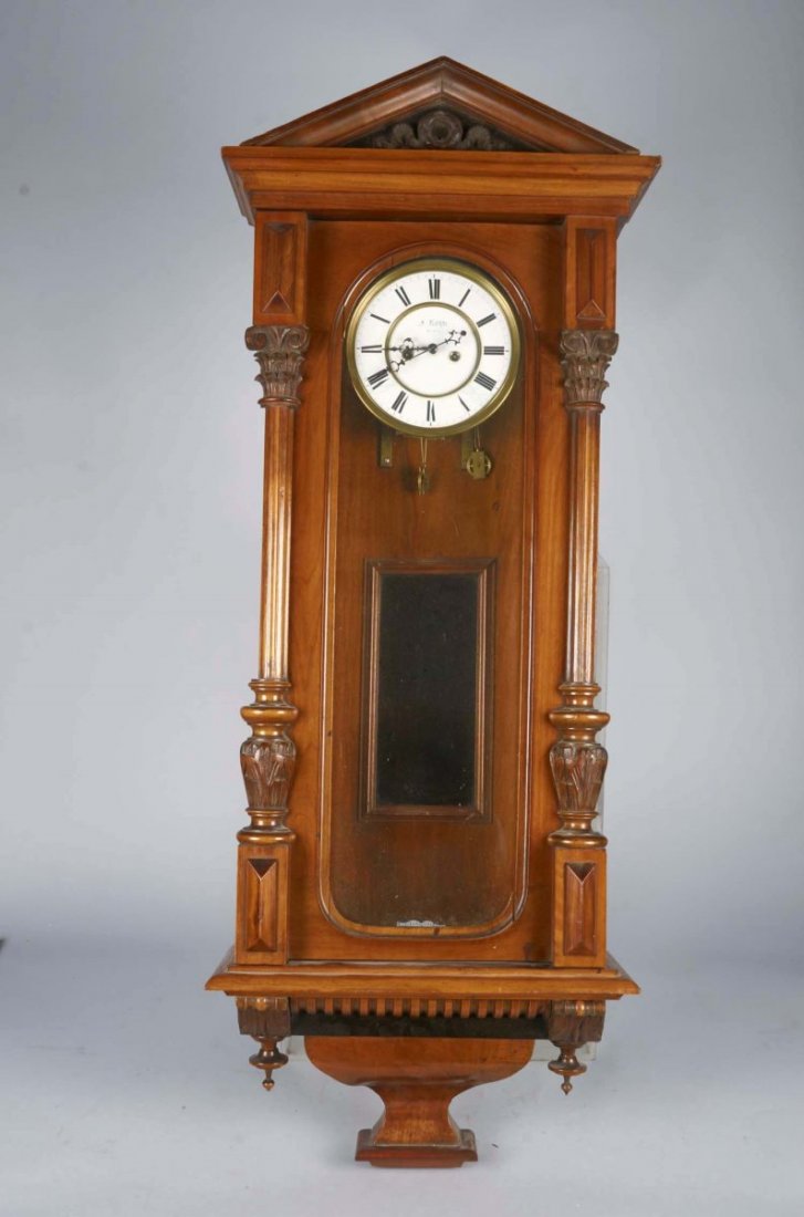 Antique Austrian Carved Wood Pendulum Wall Clock: Ornate cabinet w/ columns & pediment, Has pendulum, Roman numeral dial face marked "J. Koyn Wien" (Vienna), Glass display window Condition Very Good Size 44" x 17"
