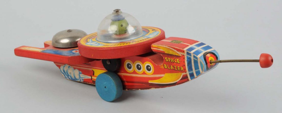 Fisher-Price Paper On Wood Space Blazer Toy.: Marked No. 750. Introduced in 1953 and made for two years. Space Ship when in operation top spins, plastic is not cracked, bell has very little wear. Condition (Very Good - Excellent). Size 14" L.