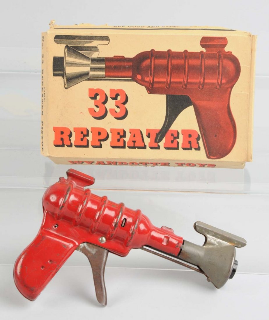 Tin & Pressed Steel No. 33 Repeater Pistol & Box.: Made by Wyandotte in the USA. Gun has some scratching and paint loss throughout but is otherwise complete. Includes the original box that has some significant creasing, paper pulls, and tears. Conditi