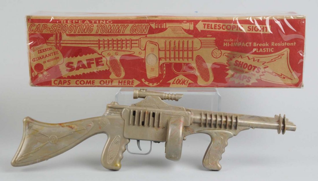 Plastic Cap Shooting Tommy Gun With Original Box.: Made by Arliss in the USA. There are some minor little scratches to the gun. Includes the original box, which has a protective plastic cover. The box itself has some slight creasing and tears around t